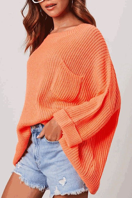 Oversized knit sweater top in vibrant orange, perfect for women’s casual dress and trendy ladies tops at a women’s boutique.