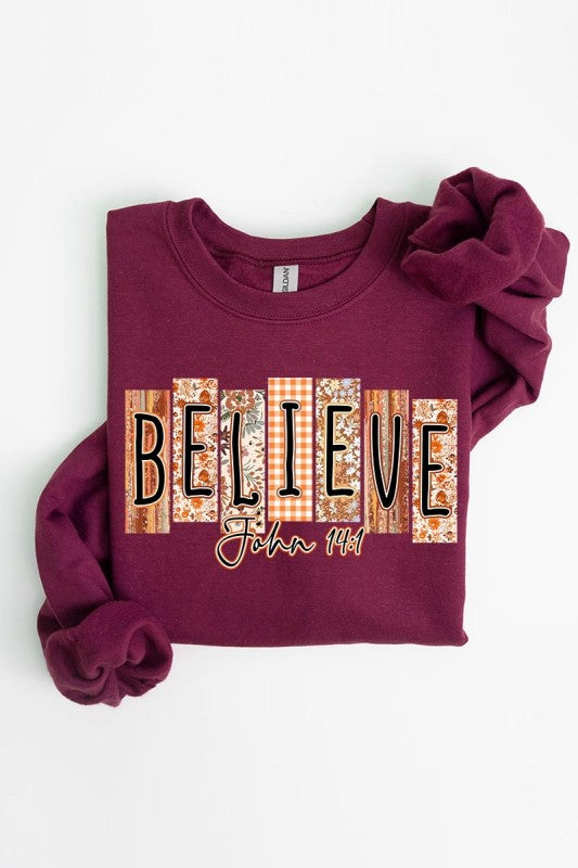 Believe Fall Christian Graphic Sweatshirt displayed on a table, showcasing women’s trendy tops and seasonal fashion.
