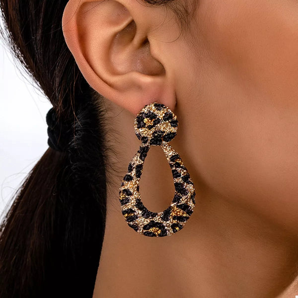 Close-up of 18K Gold-Plated Leopard Dangle Earrings worn, showcasing chic design for women’s fashion boutique.